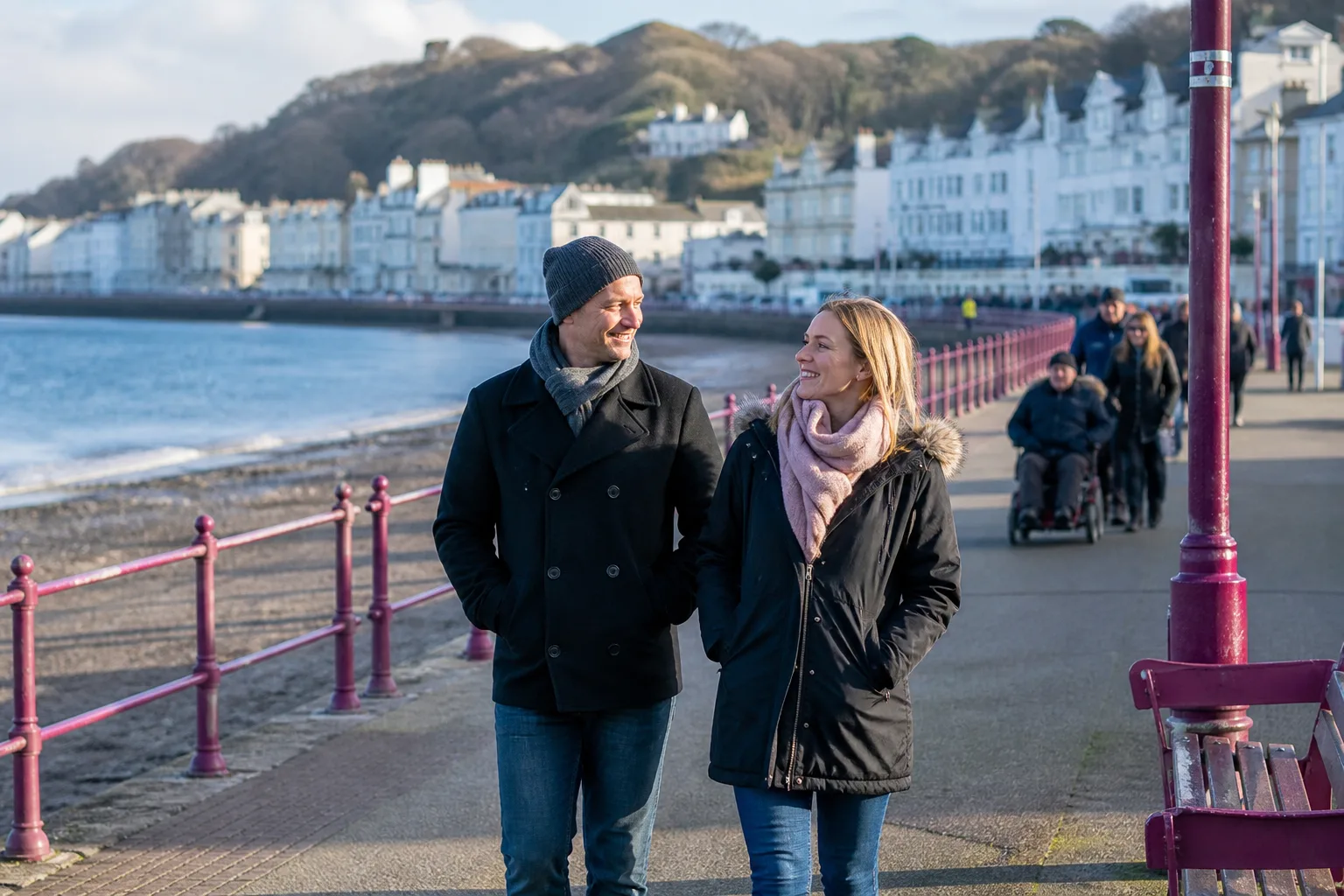 Two people talking beside the sea on the Isle of Man